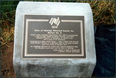 This image shows a black plaque with white printing, placed on a square block of concrete.  The inscription  reads as follows: “Shire of Hastings Historical Society Inc. Marker No. 8 Placed during Australia’s Bicentennial Year 1988 to commemorate a walk through Tyabb by William Thomas (1793-1867) Assistant Protector of Aborigines for Western Port with a party of 57 Aborigines.  ‘encamp’d at a place called Teyup....took a sketch from the hill’ wrote William Thomas on 5 February, 1840 as the party travelled from Port Phillip to Western Port.  An Australian Bicentennial project with financial assistance from the Victorian Government and the Shire of Hastings.  Tablet placed in 1988 by Renee Hill a William Thomas descendant.”  The Bicentennial  logo of the Australia map is at the top of the plaque.  