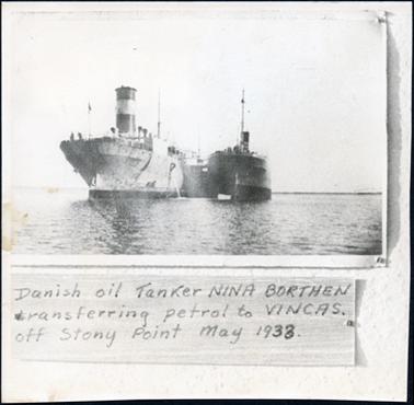 This image shows two ships, sitting side by side in the water.  The ship on the left-hand side of the photograph has a large funnel and is much larger than the one on the right.   Printed below the photograph is: “Danish oil Tanker NINA BORTHEN transferring petrol to VINCAS. off Stony Point May 1933.”.