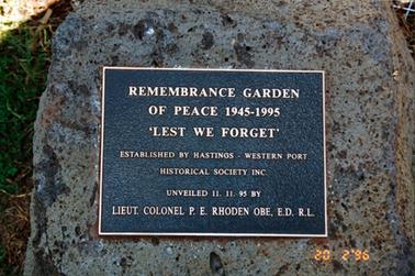 This image shows a plaque attached to a large stone.  It reads as follows: “Remembrance Garden of Peace 1945-1995 ‘Lest We Forget’ Established by Hastings-Western Port Historical Society Inc. Unveiled 11.11.95 by Lieut. Colonel P.E. Rhoden OBE ,E.D.  R.L.”.  The date 20 2 ‘96 is printed at the bottom of the photograph.  Another plaque reads: “This garden was formulated with the help of Australia Remembers Committee Brundretts & Sons (roses) P/L Debco P/L Jim Littlefield Mornington Peninsula Shire Council Northcote Pottery Services P/L Panorama Nursery Ross Roses (SA) Warren Park Nursery and memberws of Hastings Western Port Historical Society Inc. 11-11-1995”.