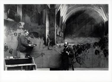 This image shows two men in front of an unfinished painting.  The man on the left-hand side is sitting on a wooden box on the top of a set of steps.  He is holding a pallet and paint brushes in his right hand a pipe in his left.  The man on the right is leaning against a stool looking at the camera.  His thumbs are in his waistcoat pockets.  