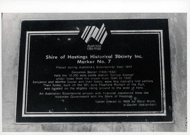 This image shows a metal plaque attached to stone.  The plaque reads: “Australia 1788-1988 Shire of Hastings Historical Society Inc. Marker No. 7 Placed during Australia’s Bicentennial Year 1988 Benjamin Baxter (1805-1892) held the 15,360 acre cattle station ‘Carrup Carrup’ under lease from the crown from 1840 to 1860.  Benjamin and Martha Baxter and their family were this district’s first settlers.  Their home, built on the 360 acre Freehold Portion of the Run, was located on the slightly rising ground to the west of here.  An Australian Bicentennial project with financial assistance from the Victorian Government and the Shire of Hastings.  Tablet placed in 1988 by Beryl Monk, a Baxter descendant”.