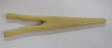 Cream coloured bakelite glove stretcher.  Two pieces hinged at the centre so when squeezed together it opens the other end when placed in the fingers of a glove (usually leather)to stretch.