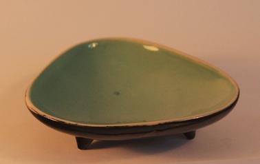 Triangular dish with black glaze on the outside and duck-egg blue glaze on the inside, on three short legs.