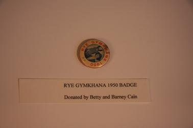 Metal badge with coloured transfer “Rye Gymkhana 1950”.  Stamped with No. 68 around margin.  Photograph of horse and lady rider (heads only).