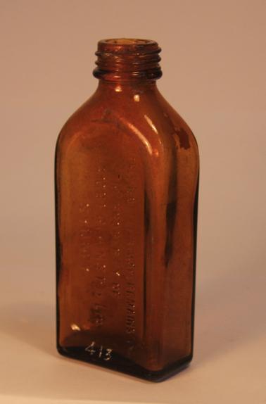Brown coloured glass bottle with straight sides and small screw top spout. The words “THIS BOTTLE ALWAYS REMAINS THE PROPERTY OF CHAMBERLAINS PTY. LTD SYDNEY” has been stamped  into one side.