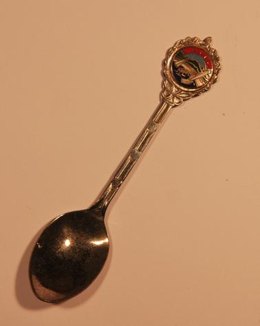 Teaspoon with enamel badge showing pier,beach and 2 yachts - stylised “Rye” on top 