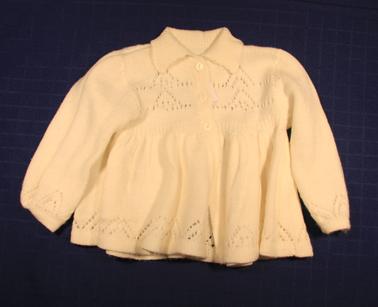 White knitted jacket with collar. 3 pearl buttons to waist. Long sleeves