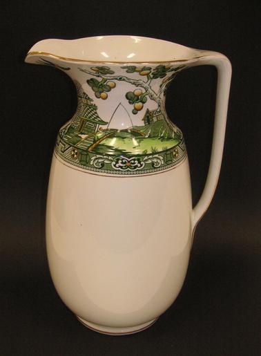 White jug with green Asian-style decoration around top part of jug.  Gold edging.  