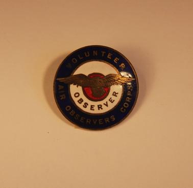 Volunteer Air Observers Corp.   Circular badge with blue, white and red circles with bird superimposed over them.