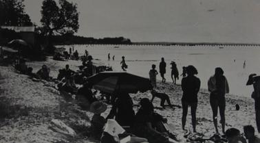 The image depicts people sunbathing on Rye beach east of pier during the 1950’s