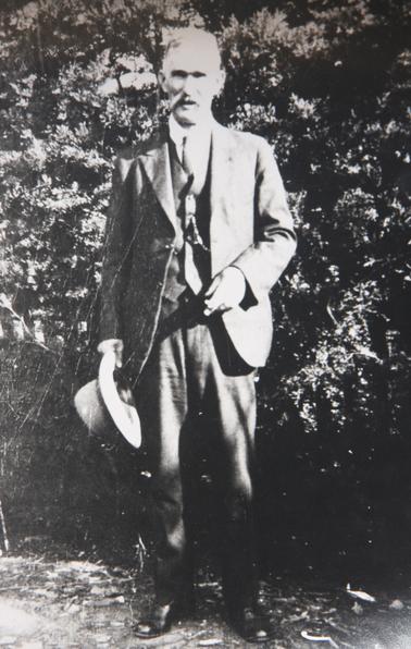 James Rowley in 3-piece suit, holding a hat.
