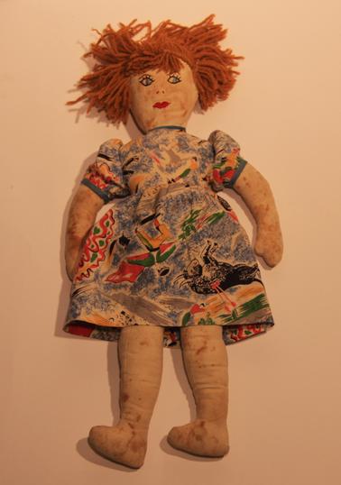 Child’s doll - Calico body stuffed with cotton.  Woollen hair, cotton dress and underwear.  Embroidered facial features.