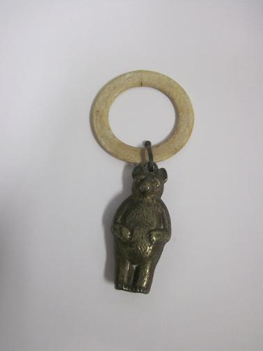 Bone ring with toy metal bear attached