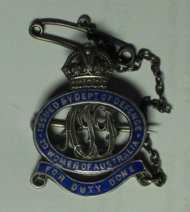 Sterling Silver badge with blue enamelling. Crown emblem at the top.  Letters AIF in the oval centre of the badge.  Badge no 29016. Words : “ISSUED BY DEPT OF DEFENCE TO WOMEN OF AUSTRALIA.  FOR DUTY DONE”.  Safety chain attached.
