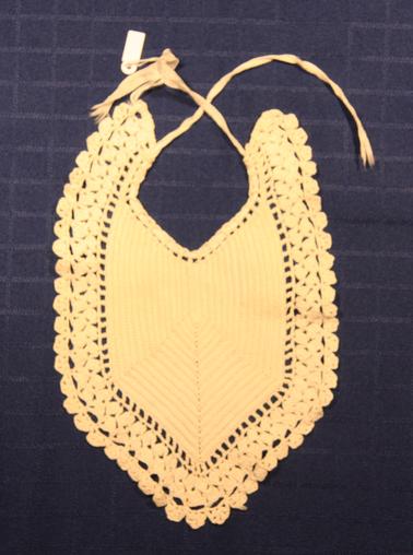 White crocheted babies bib with ribbon & tie.