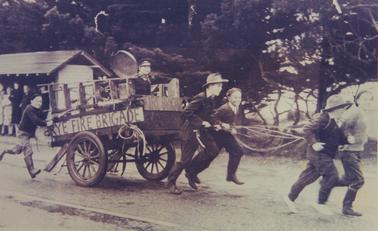 Members of the Anderson Family pulling a cart labelled “Rye Fire Brigade” during a parade at Rye during the 1940s.  L to R: Kevin, Arthur (with fire gong) cousins Greg, Vin, Bob and ‘Hap’.  Cousin Doug is obscured behind trailer.