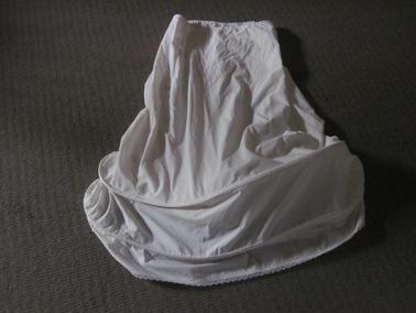 Long (from waist) petticoat, draw tape at waist, two hoops, inserted - 10cm from bottom and 15cm above the first one.  Lace edge sewn around bottom.