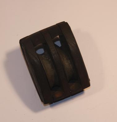 Wooden oval block to enable ropes to be pulled through for rigging. Three sections with four spacing blocks, two brass concave wheels (50 mm dia.)  Held together with 5 brass rods.