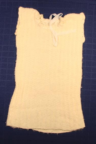 Hand knitted baby singlet.  Ribbon thread drawstring at neck.
