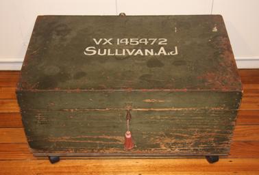 Large wooden trunk with name and service number on lid.  (VX145472  Sullivan, A.J.)
Simple catch to hold padlock.  Green/khakii colour.