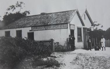Gracefield Hotel late 1800's taken from east. 5 people in front, 3 bicycles, man in white with knickerbockers, one with straw boater. 
