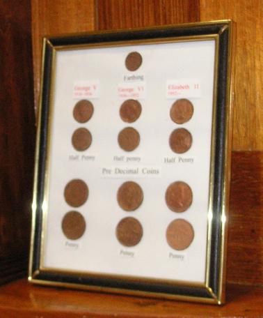 Black and gold framed collection of 13 pre-decimal coins, dating from 1914 -1963.