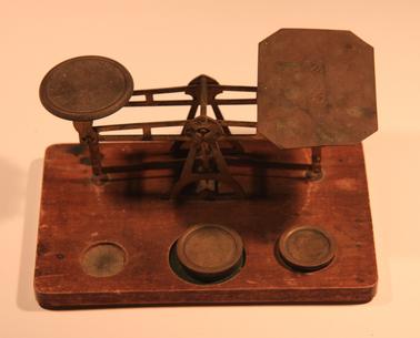 Post Office Scales (brass).  Wooden base with two weights. 2 ounce place has weight missing.