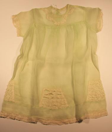 Pale green dress.  Sheer material.  Lace around sleeves, neck and base.  Lace patches around lower part of dress.