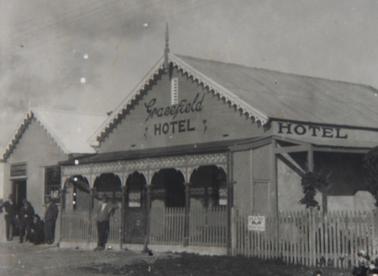 Gracefield Hotel c. 1915+ from NorthEast 5 men outside - picket fence - Plume sign 
Mounted on cardboard.  