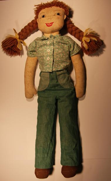 Handmade cloth doll.  Calico body stuffed with cotton wadding.  Cotton shirt and Jeans.  Felt shoes,  woollen hair.  Embroidered facial features.