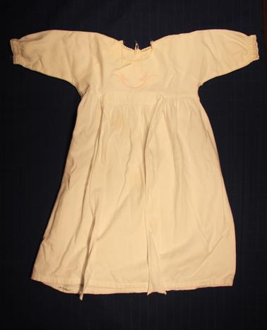 White baby nightdress - long sleeves.  Fine fleecy lined cotton. Pink handwork on bodice.  Lace around neck and wrists.