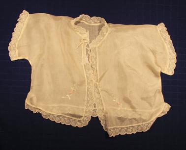 White silk matinee jacket. Lace edging. Pink rose on each side at base