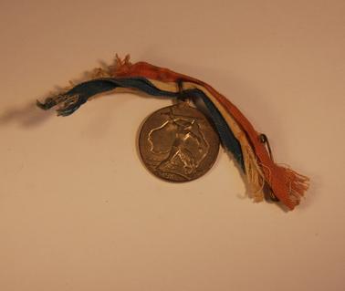 Australian Victory Medal (1945) denoting map of Australia, overlaid with Aboriginal figure, with red, white and blue ribbon.