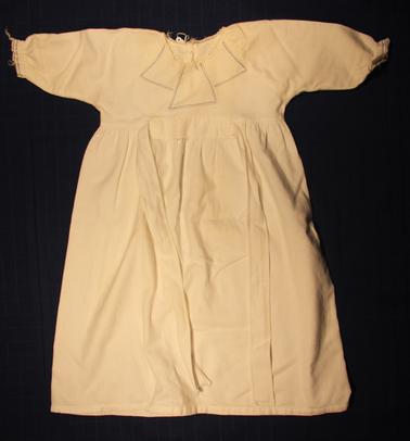 White baby nightdress - long sleeves.  Fine fleecy lined cotton. Blue stitching on sleeves and blue stitched pattern on bodice.