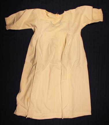 White baby nightdress - long sleeves.  Fine fleecy lined cotton. Blue handwork on bodice.  Lace around neck and wrists.