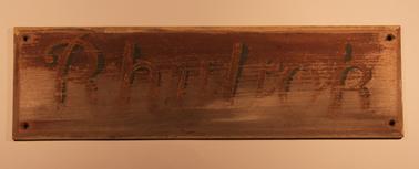 Wooden house sign “Rhylrok”. Origionally painted.  Name in yellow on brown background.