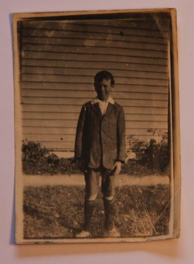 Alan Sullivan at about 8 years old in 1913.  Wearing an open necked white shirt, blazer, knee length pants, long socks, shoes.