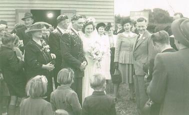 Wedding at Rye Presbyterian Church. Bride (Lesley Tyler) and Groom (Barney Hill) in centre of photograph with guests surrounding them.  Children in foreground. Guests included : Bessie Tyler, (Left of bridgegroom): Vic Tyler (on right, with buttonhole) George Hill (Groom’s brother).