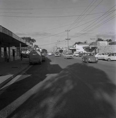 A street scene with shops and cars.