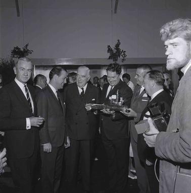 Seven men in suits posing for a photograph.