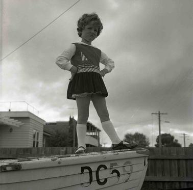 A girl posing on the prow of a boat.