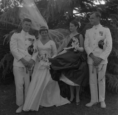 Bride and groom with two attendants.  The men are wearing white naval uniforms.