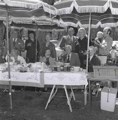 Picnickers at their umbrella shaded tables.