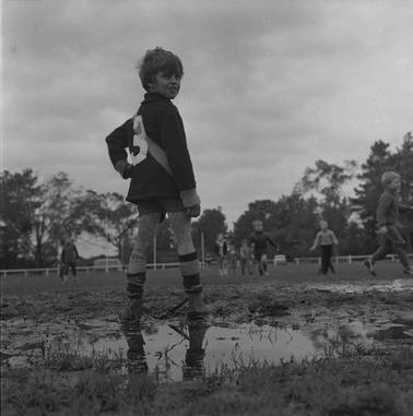 A young football player with others playing in the backgrouno date.