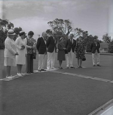 Nine men and women in Bowling Club uniforms posing for the photograph.