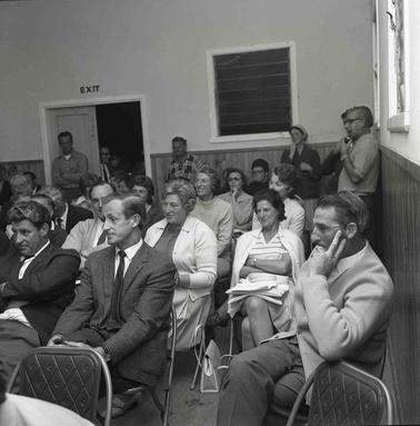 Men and women seated on chairs at a meeting.