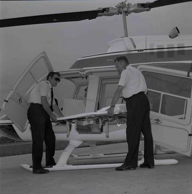 Two men in shirt sleeves at a helicopter.