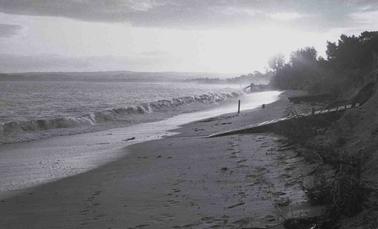 Beach scene with roug waves buffting some boat ramps.