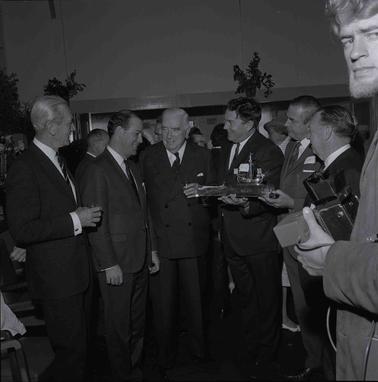 Seven men in suits posing for a photograph.