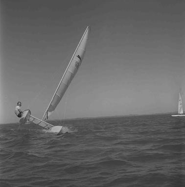 A man sailing a tipping catamaran.